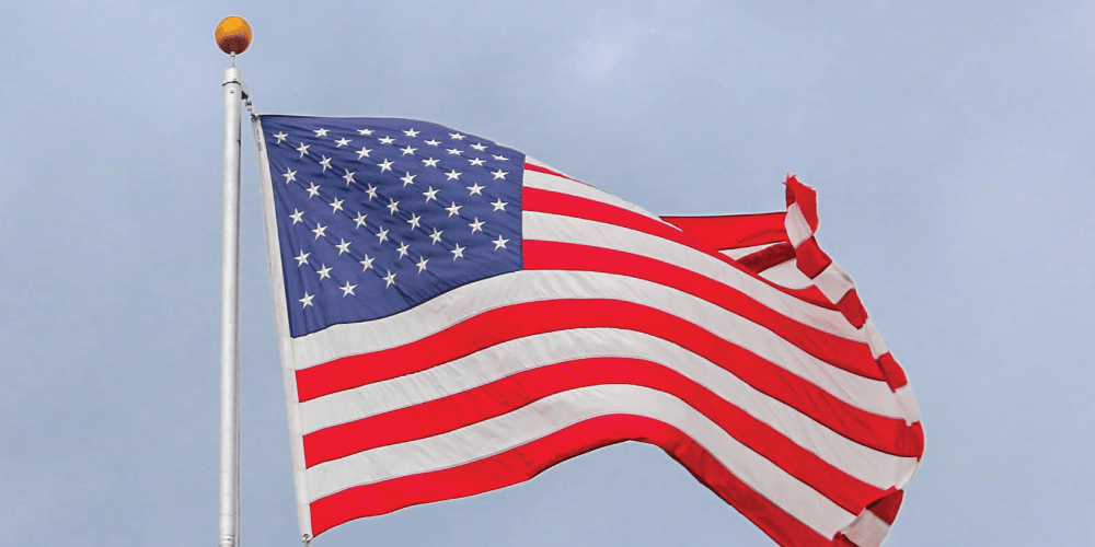 USA flag waving on a white pole