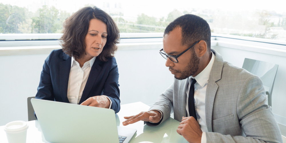 White business woman and Black business man work on a computer in an office