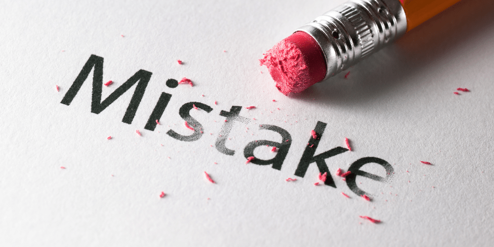 erasing the word mistake with a pencil eraser
